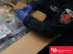 Funkcjonariusz Służby Celno-Skarbowej trzyma w rękach blistry z tabletkami